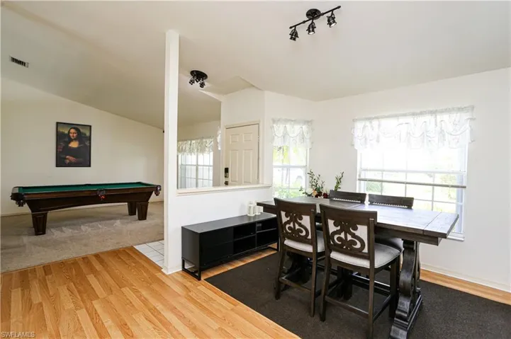 Dining space featuring hardwood / wood-style floors, lofted ceiling, and pool table