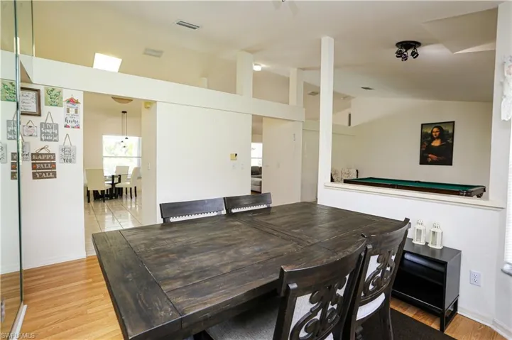 Dining area with light hardwood / wood-style floors, lofted ceiling, and billiards