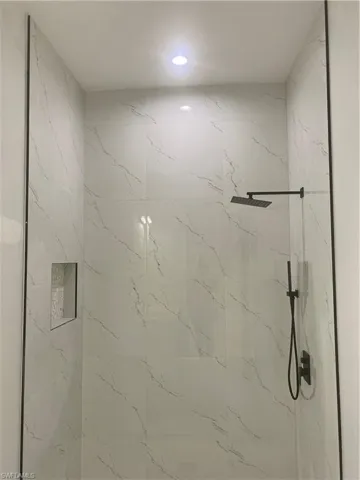Bathroom featuring a marble finish shower and recessed lighting