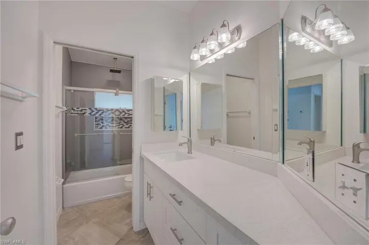 Bathroom with vanity and a combined bath / shower with rainfall shower
