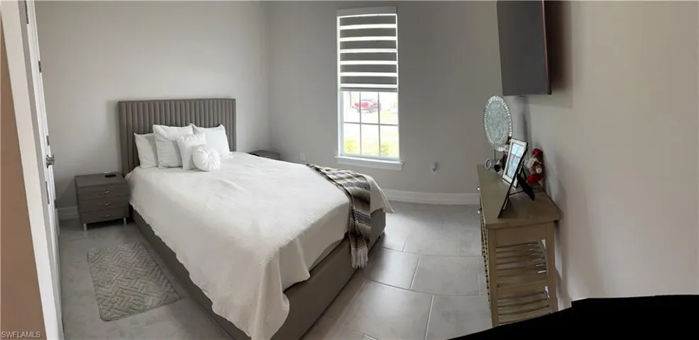 Light-toned wall paint throughout, large format tile flooring, and a window with horizontal blinds