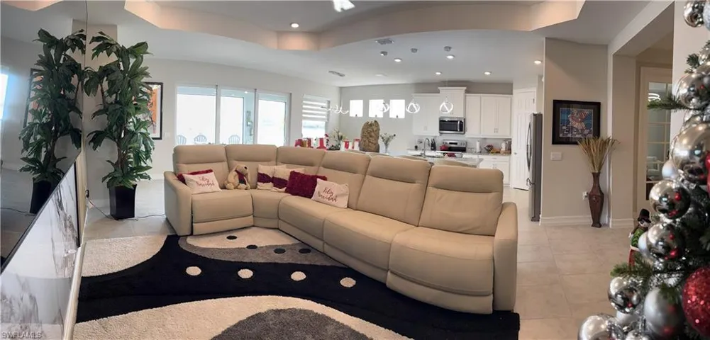 Open-concept living area with tray ceiling and recessed lighting