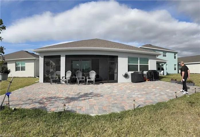 Expansive paver patio with a screened lanai and sliding glass door entry