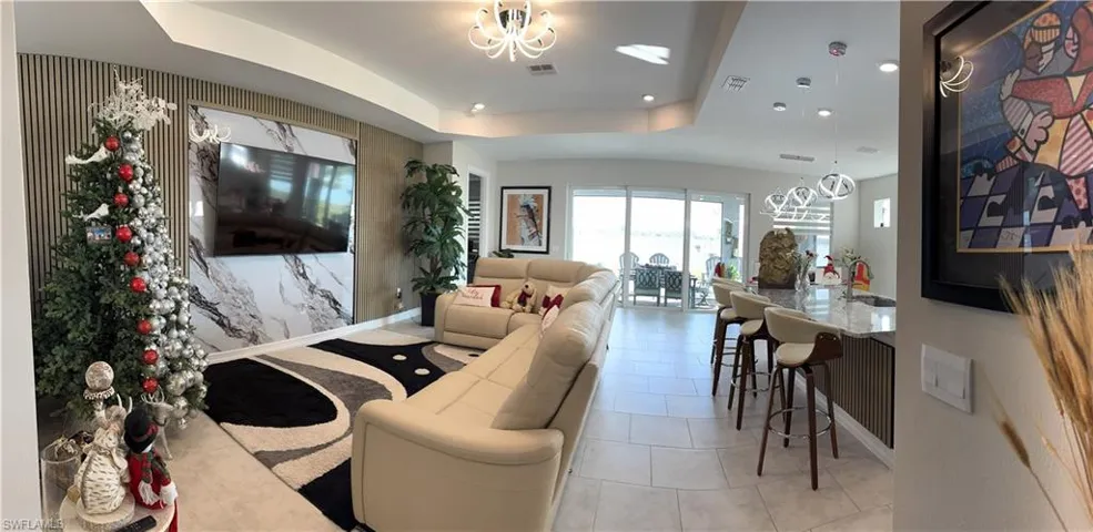 Open-concept living space with large format tile flooring and recessed lighting