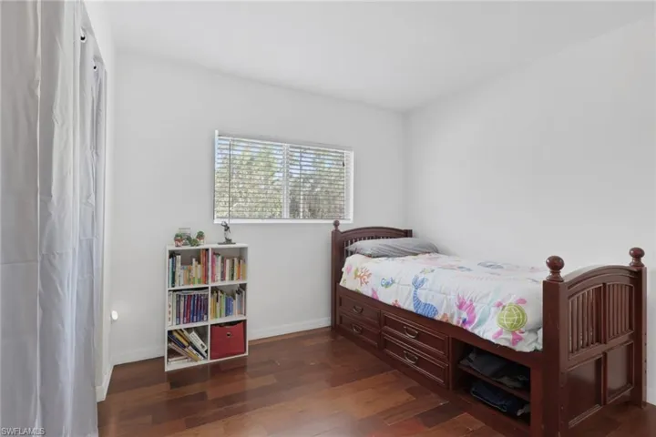 Bedroom featuring dark wood finished floors and baseboards