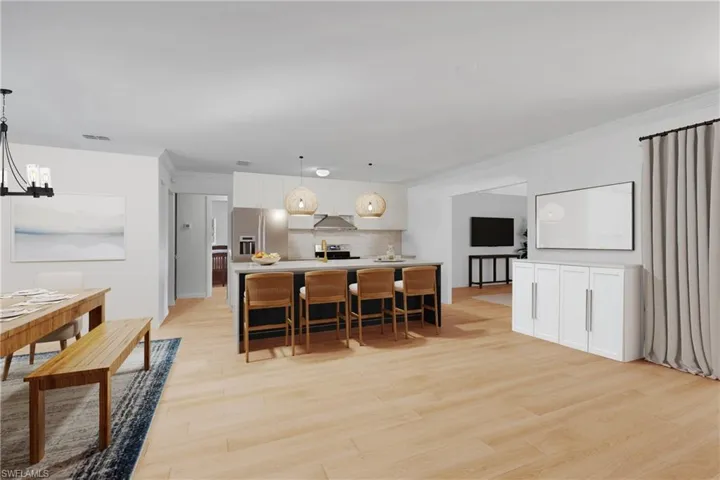 Photo includes reality renovation and/or staging to showcase the possibility of the Kitchen layout. Design services included with purchase! decorative light fixtures, light wood finished floors, a chandelier, and a kitchen bar