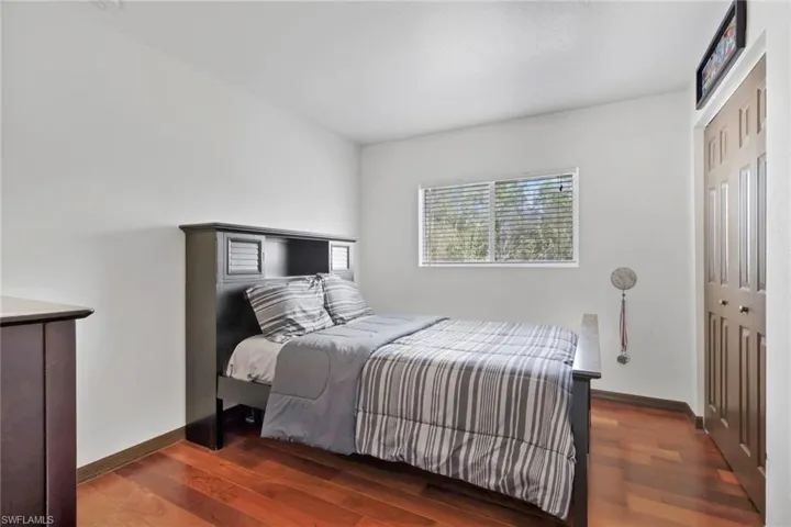 Bedroom featuring dark wood-style floors and a closet