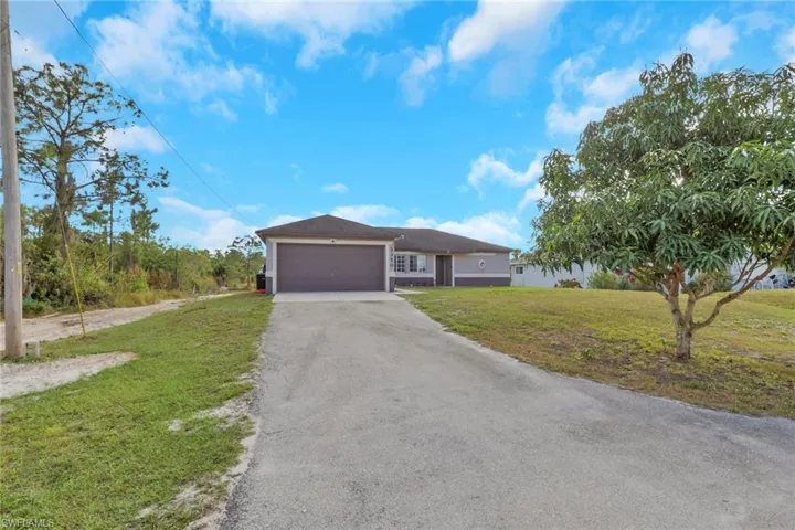 Ranch-style home with a front lawn, asphalt driveway, and an attached garage