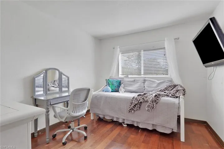 Bedroom featuring wood finished floors and an office area