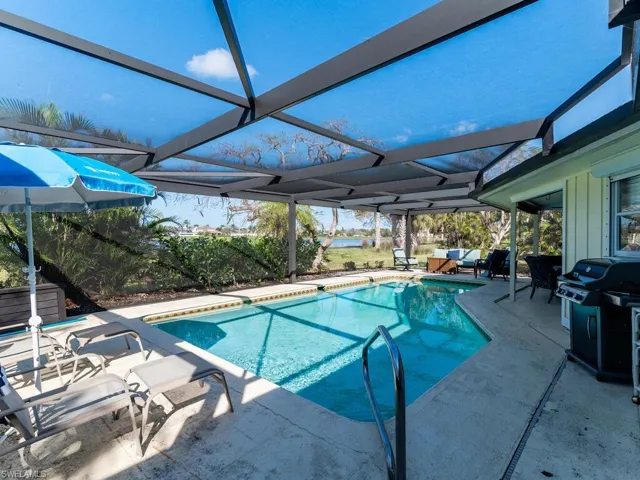 View of swimming pool featuring a patio area and a lanai