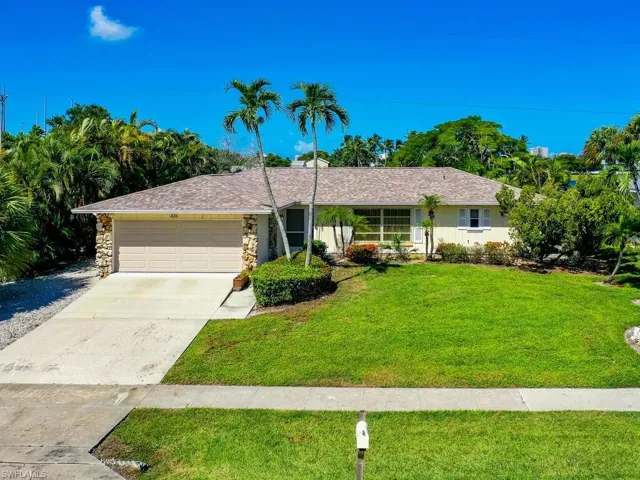 Ranch-style home with a garage and a front lawn