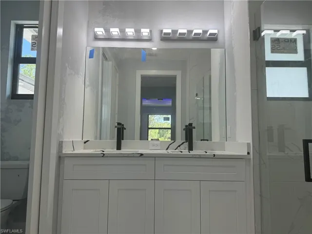 Bathroom with dual bowl vanity and toilet
