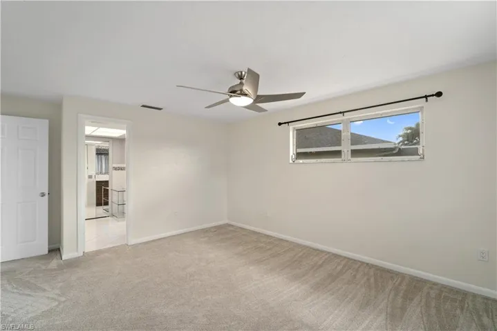 Spare room with carpet, ceiling fan, and baseboards