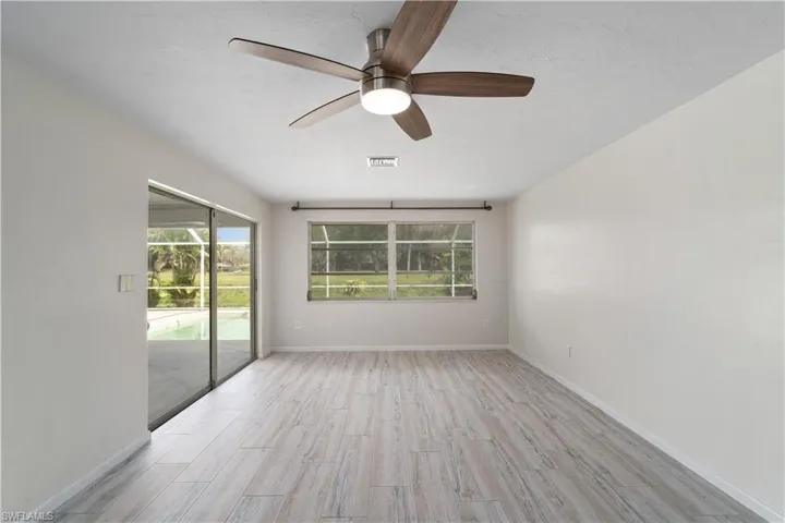 Spare room featuring light wood-style flooring, ceiling fan, and baseboards