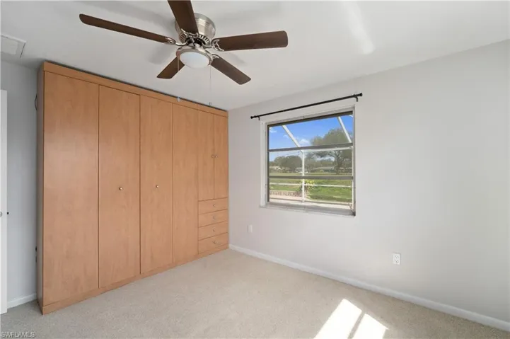 Unfurnished bedroom with light carpet, baseboards, and a ceiling fan