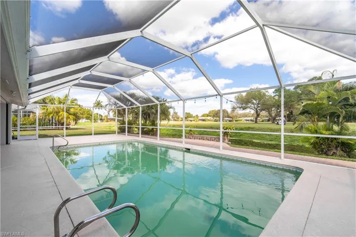 Swimming pool featuring a patio and glass enclosure