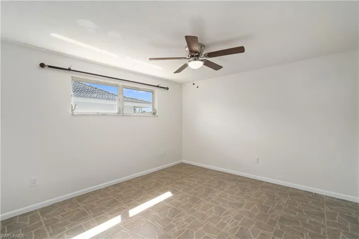 Spare room featuring ceiling fan and baseboards