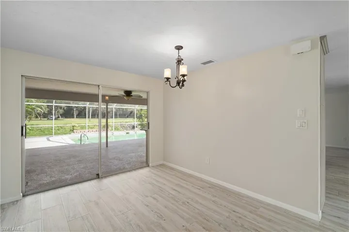 Unfurnished room with wood finished floors, baseboards, a chandelier, and ceiling fan