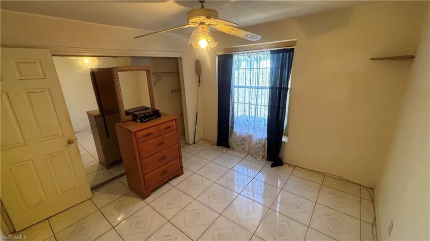 Bedroom with a ceiling fan, a closet, and light tile patterned floors