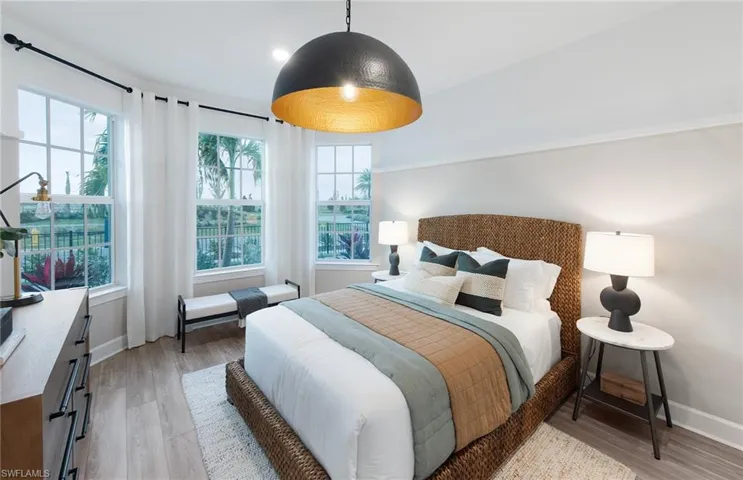 Bedroom with multiple windows and hardwood / wood-style flooring
