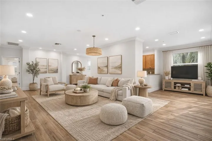 Living room featuring light wood-style floors, recessed lighting, and crown molding