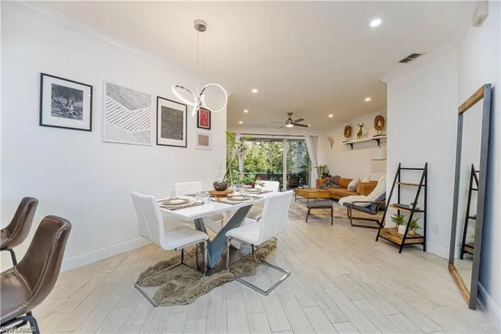 Dining room with light wood-type flooring, recessed lighting, a ceiling fan, and crown molding