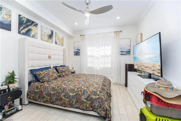 Bedroom with wood finish floors, crown molding, ceiling fan, and recessed lighting