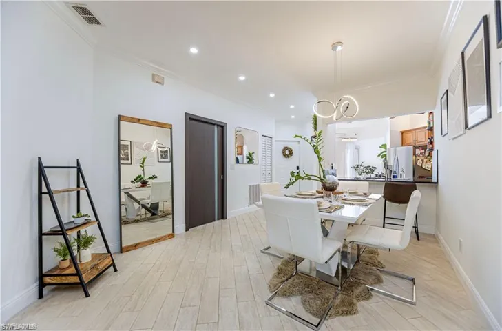 Dining space with crown molding, recessed lighting, and light wood finished floors