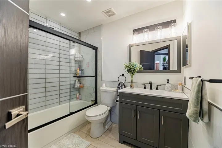 Full bath featuring vanity, enclosed tub / shower combo, and recessed lighting