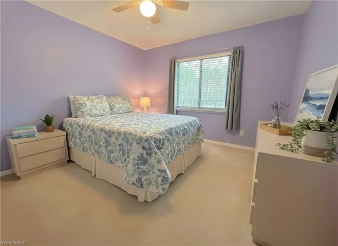 Bedroom with light carpet and a ceiling fan
