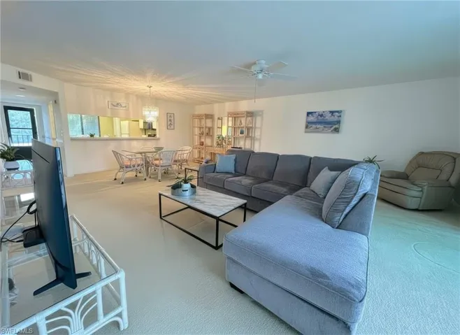 Living area with a ceiling fan and carpet