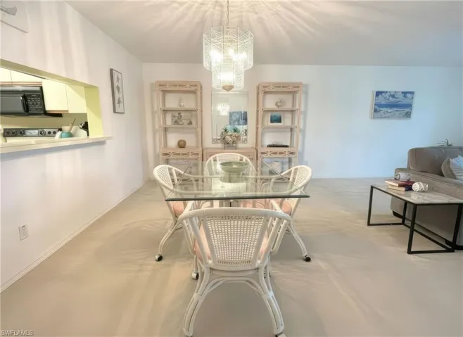Dining area with a chandelier and light colored carpet