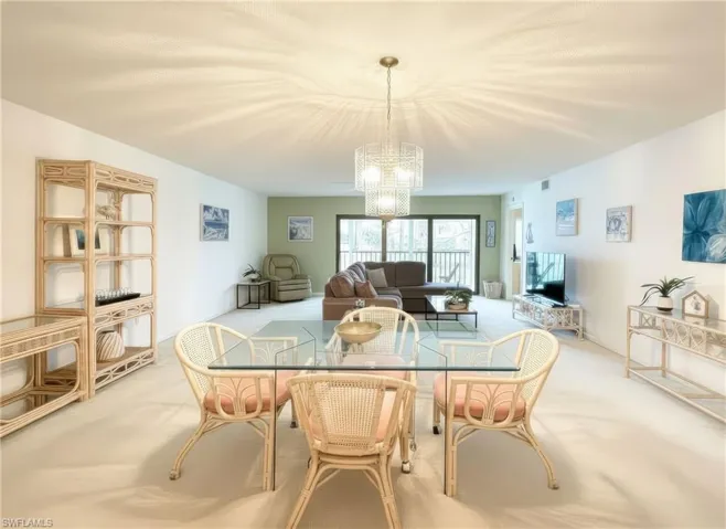 Carpeted dining area with a chandelier