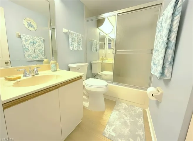 Bathroom with vanity and shower / bath combination with glass door