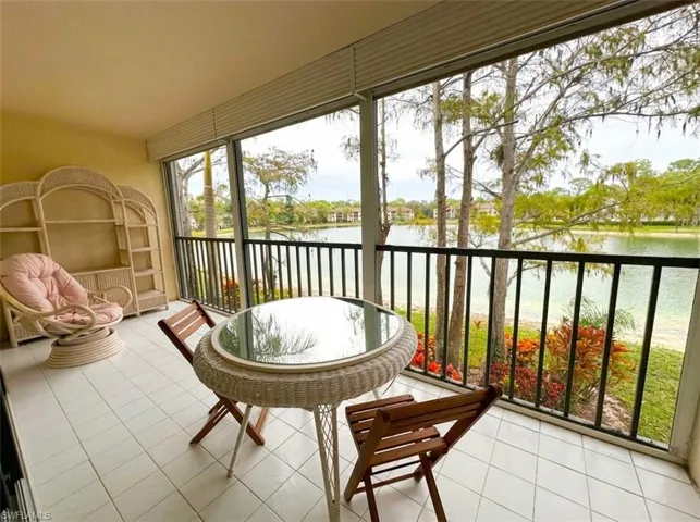 Sunroom / solarium featuring a water view and tile patterned floors