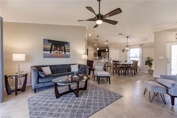Tiled living room featuring crown molding and ceiling fan
