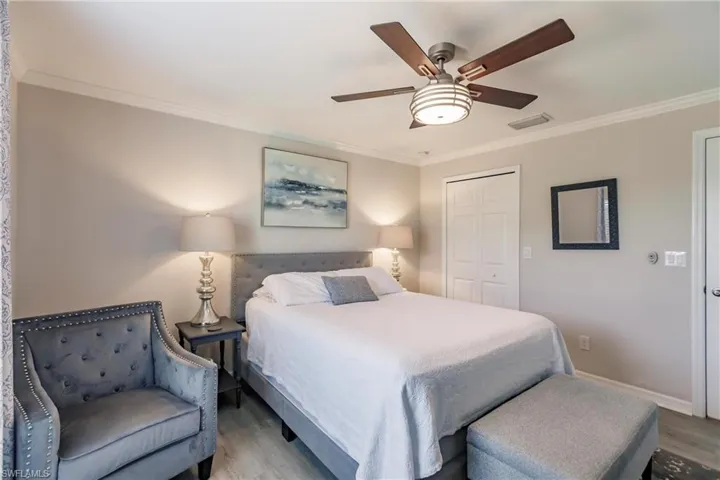 Bedroom featuring ceiling fan, a closet, hardwood / wood-style flooring, and crown molding