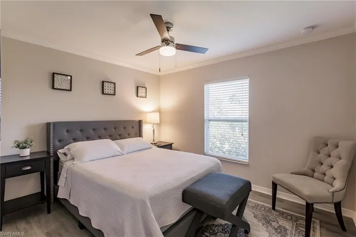 Bedroom featuring hardwood / wood-style flooring, ornamental molding, and ceiling fan