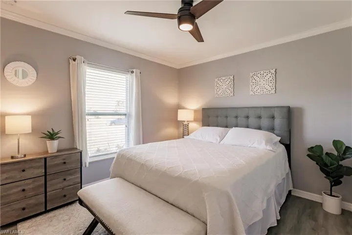 Bedroom with ornamental molding, ceiling fan, and hardwood / wood-style floors