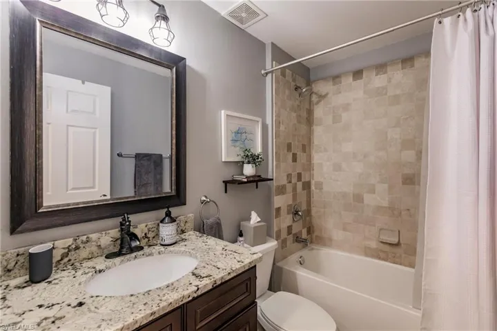Full bathroom featuring vanity, toilet, and shower / tub combo with curtain