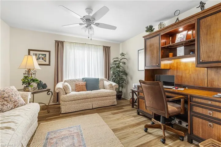 Office featuring ceiling fan, built in desk, and light hardwood / wood-style floors