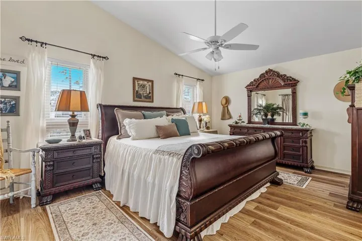 Bedroom with ceiling fan, lofted ceiling, and light hardwood / wood-style flooring
