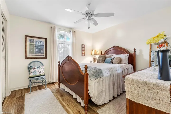 Bedroom with ceiling fan, light hardwood / wood-style floors, and a closet