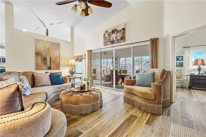 Living room featuring ceiling fan, light hardwood / wood-style flooring, and high vaulted ceiling