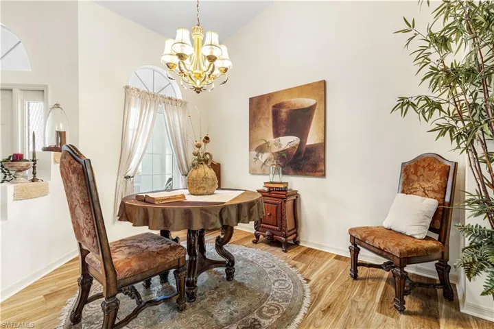 Dining area featuring high vaulted ceiling, light hardwood / wood-style flooring, and a chandelier
