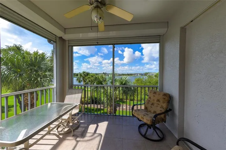 Sunroom with ceiling fan and a water view