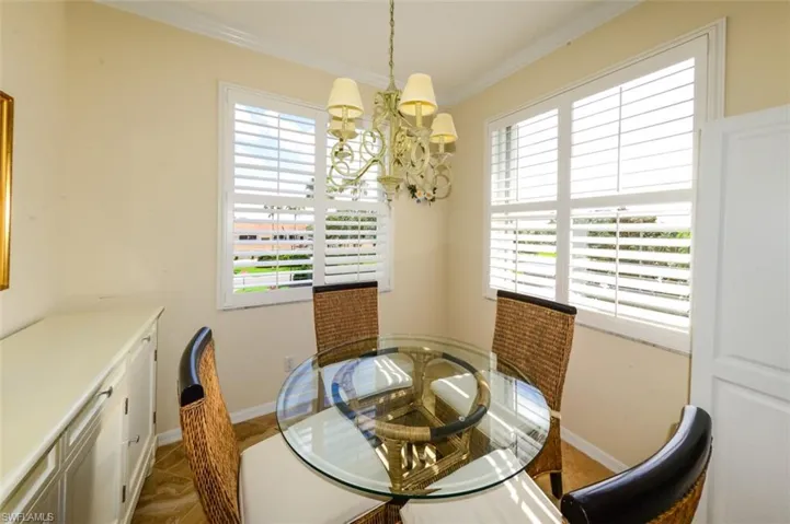 Dining area with ornamental molding and a chandelier