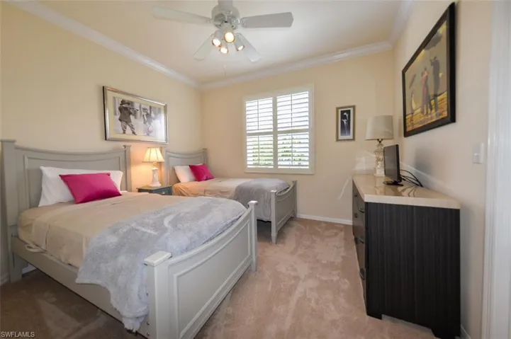 Bedroom featuring ceiling fan, light carpet, and ornamental molding