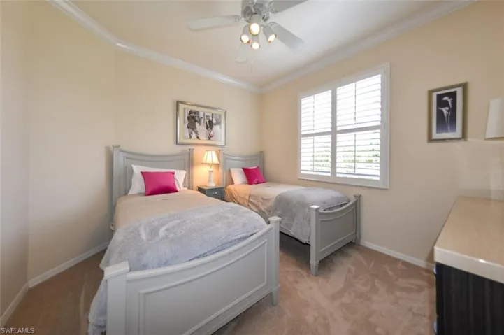 Bedroom with light carpet, ornamental molding, and ceiling fan