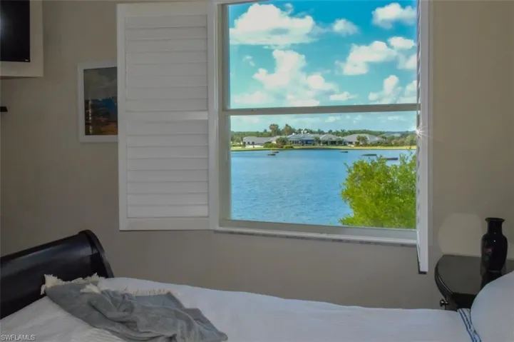 Bedroom with multiple windows and a water view